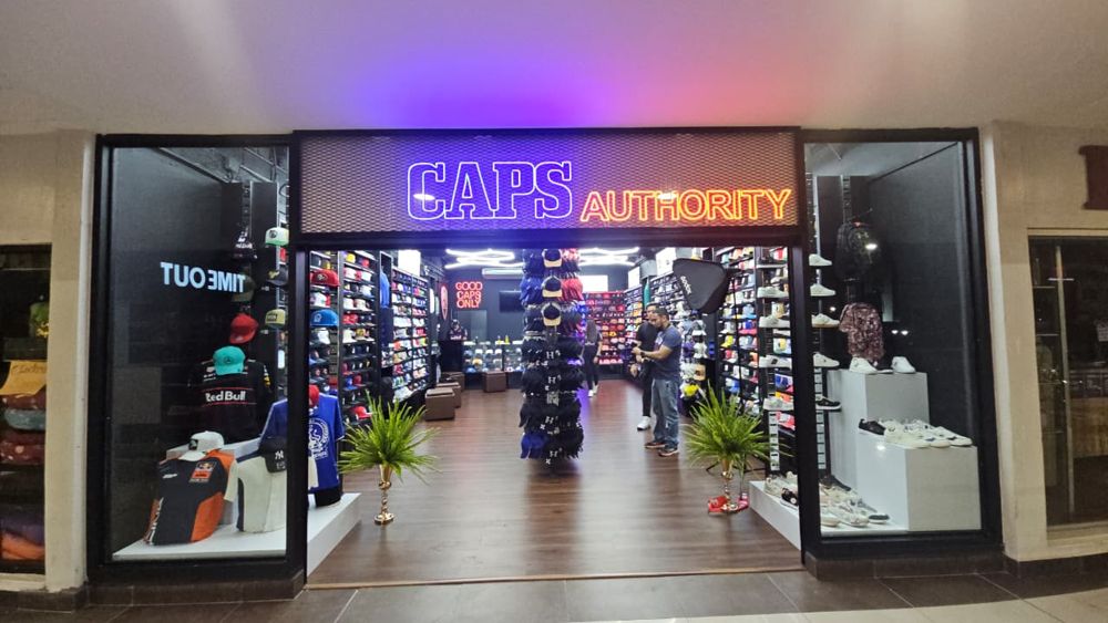 Fachada terminada de la tienda Caps Authority con rótulo de neón