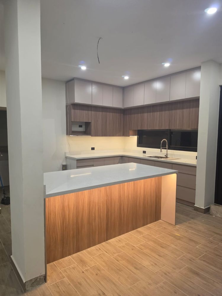 Cocina en L con gabinetes altos en dos tonos