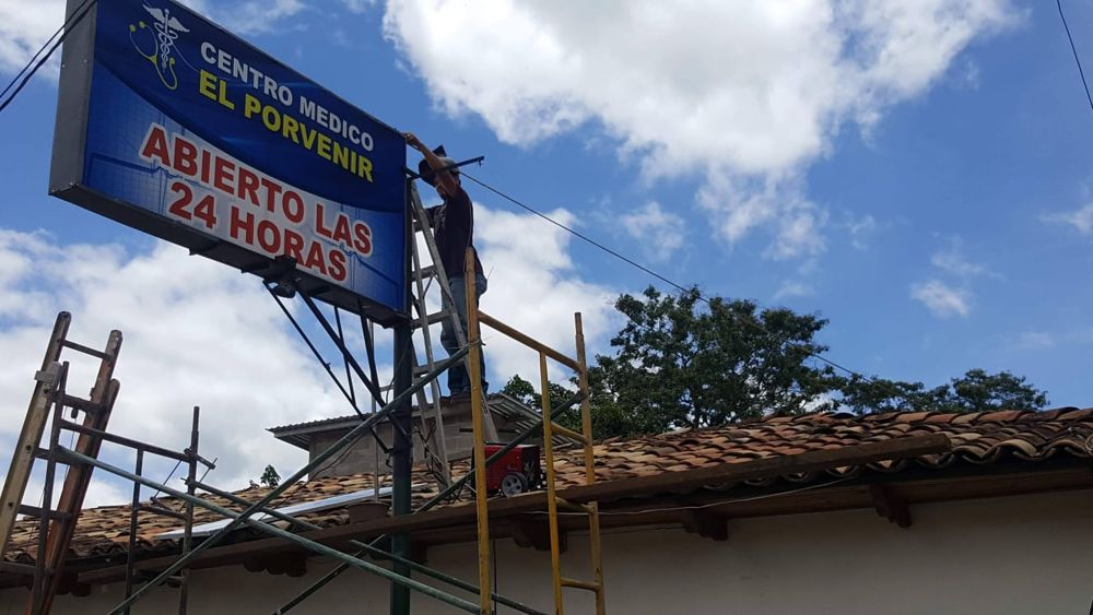 Técnico conectando el rótulo luminoso del centro médico