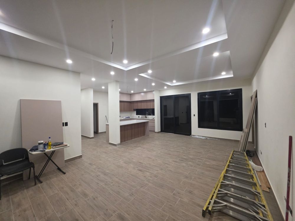 Sala y cocina abierta con cielo falso iluminado