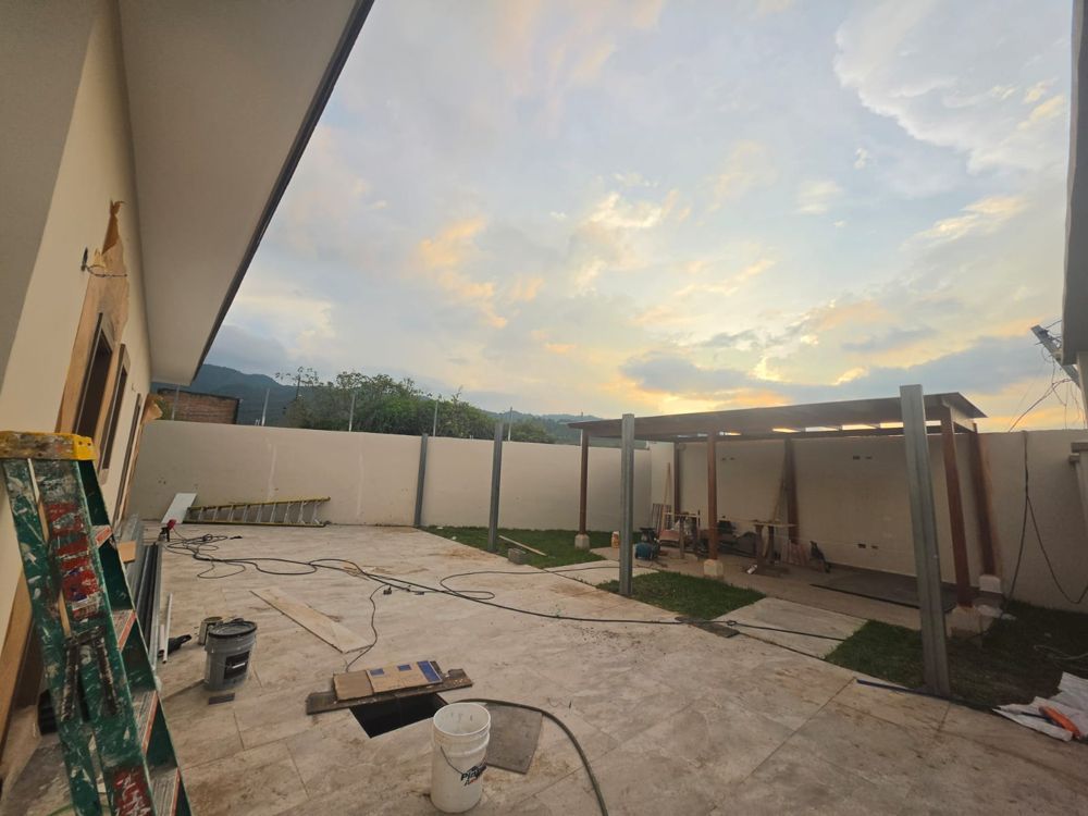 Vista amplia del patio con pérgola y grama