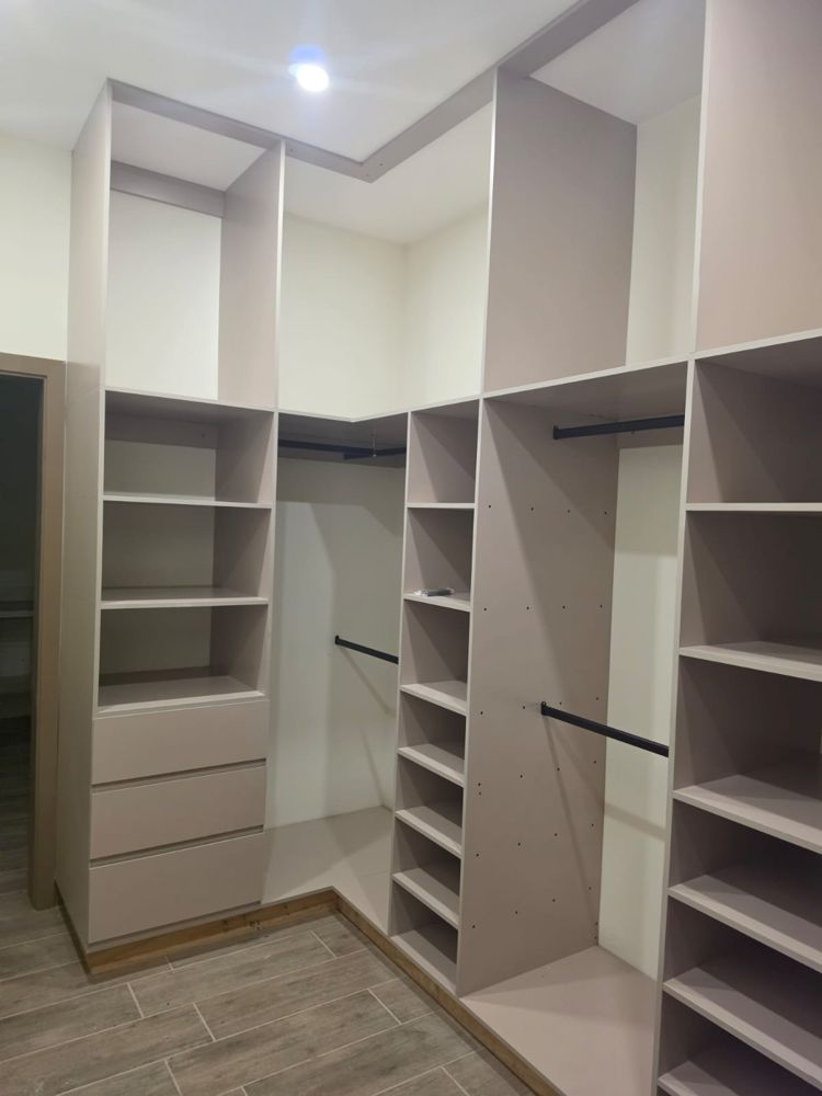 Walk-in closet en L con repisas y tubos